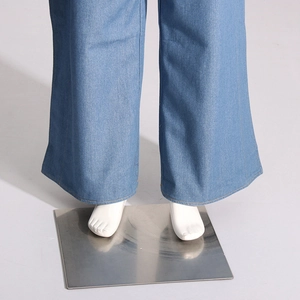 Gros plan du bas d'un jean large montrant les coutures jaunes précises sur denim