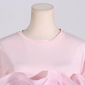 Detail of the elegant light pink T-shirt featuring pleated ruffles and a round neckline