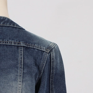 Detailed macro of dark blue denim jacket shoulder with yellow contrast stitching
