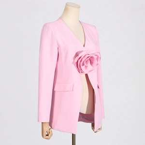 Detail of a pink slim blazer featuring a large 3D floral accent and a deep V-neckline