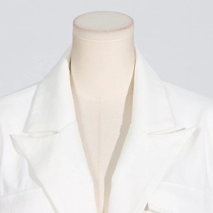Detailaufnahme von Revers und Schulternähten des weißen Blazers mit Nietenbesatz