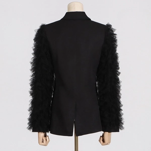 Detail of sheer tiered mesh sleeves and back slit on a black tailored blazer