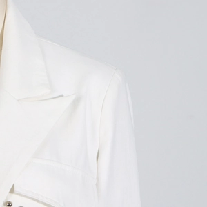 Detailansicht eines weißen Blazers mit steigendem Revers und hochwertiger Textur