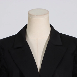 Detail of classic notched lapel and textured fabric on black fashion blazer for women