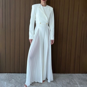 Détail de l'ensemble blazer blanc avec boutons dorés et pantalon large en tulle fendu