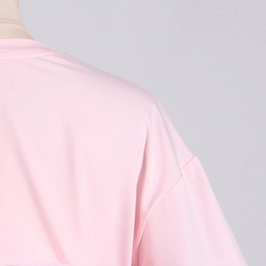 Detail shot of the shoulder stitching and pink fabric texture of the slim fit t-shirt