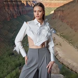 Detailansicht der weißen schulterfreien Crop-Bluse mit Federbesatz und grauer weiten Hose