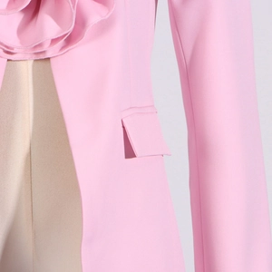 Detail of pink blazer with ruffled collar, decorative pocket and fine stitching
