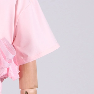Detail view of pink T-shirt featuring elegant pleated side ruffles on light fabric