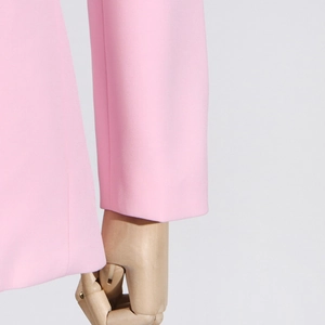 Detail of pink cropped cardigan showing premium woven fabric texture and refined stitching