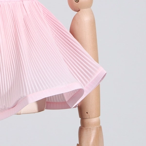 Macro detail of pink pleated chiffon skirt fabric showing fine texture and sewing finish