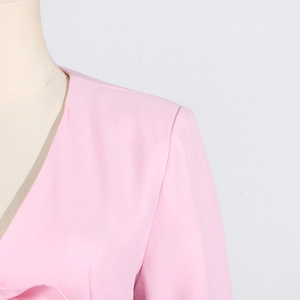 Detailed view of the V-neck and shoulder seam on a pink long-sleeve women's blazer jacket
