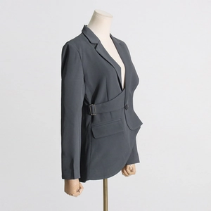 Detail view of charcoal gray asymmetrical blazer with side metal buckle and buckle belt