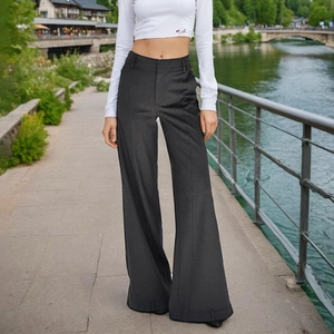 Détail du pantalon large gris foncé à taille haute avec un drapé élégant et ourlet