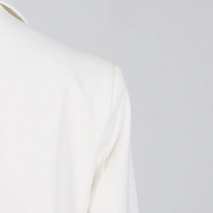 Detail der Schulternaht eines weißen Oversize-Blazers mit präziser Verarbeitung und Stoff
