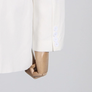 Detailansicht des weißen Blazer-Ärmels mit vier eleganten Knöpfen auf einem Mannequin