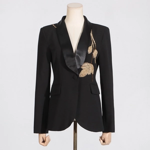 Close-up of golden leaf bead embroidery and satin lapel on black slim blazer