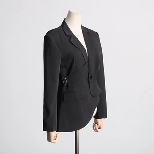 Detail of black fitted blazer featuring cutout waist and adjustable metal buckle design
