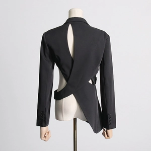 Detail showing asymmetric cutout design and buttons on the back of black blazer