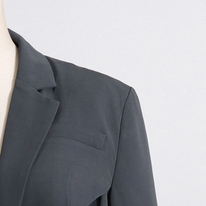 Close-up of charcoal gray blazer with notched lapel and fine fabric texture detail