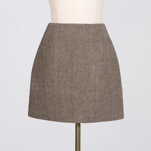 Detail of the elegant brownish-grey herringbone pattern fabric on a high-waisted mini skirt
