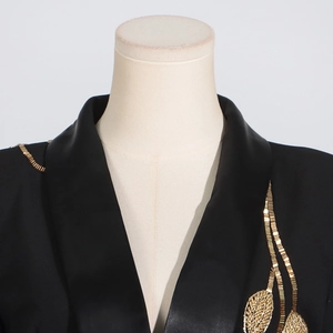 Close-up of black blazer with satin shawl lapel and gold leaf-shaped bead embroidery