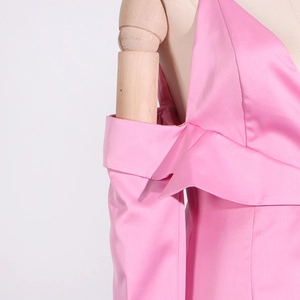 Détail du blazer en satin rose avec design épaules dénudées et texture soie brillante