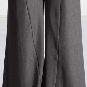 Détail du pantalon large gris anthracite montrant le tissu tissé et son tombé élégant