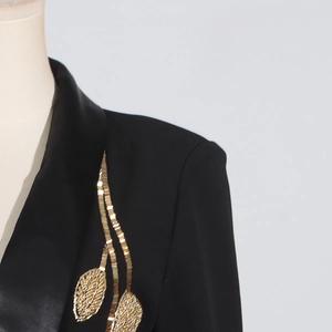 Close-up of black blazer with satin lapel and golden leaf embroidery detail