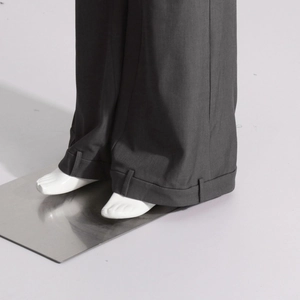 Détail du pantalon gris montrant l'ourlet à revers unique avec passants de ceinture
