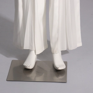 Détail du pantalon plissé blanc à jambes larges avec une texture fluide et ourlet net