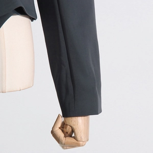 Detailed view of the dark grey suit jacket showing refined sewing and woven fabric texture