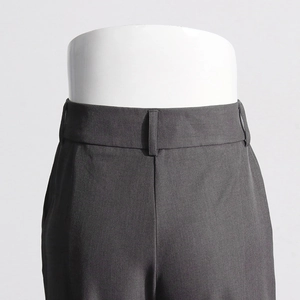 Détail de la taille haute large et des passants de ceinture sur ce pantalon gris foncé