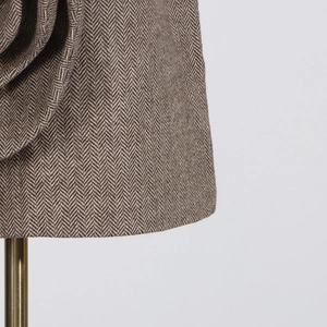 Detail shot of grey herringbone tweed fabric on a high-waisted A-line mini skirt