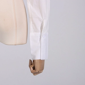 Detailansicht der weißen Hemdmanschette mit Einzelknopf auf Holzmannequin