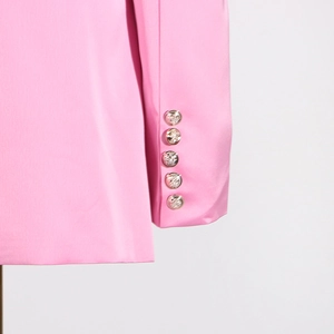 Détail de la manchette d'un blazer rose avec cinq boutons en métal argenté texturé