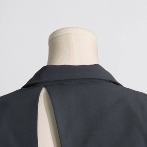Detail of the hollow-out back design and fine woven fabric of the black fitted blazer