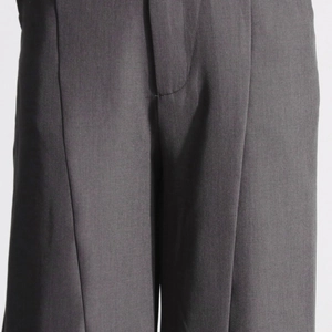 Détail du pantalon large gris foncé montrant les plis et la texture du tissu