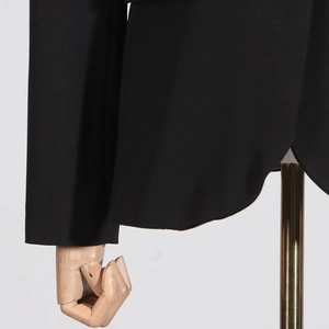 Detail view of the black blazer curved hemline with high-density smooth fabric texture
