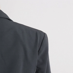 Detail shot of structured shoulder pad and premium woven fabric on slim blazer