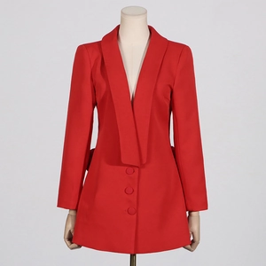 Détail d'un blazer rouge montrant le col châle et les boutons recouverts de tissu