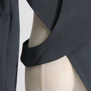 Detail shot of black blazer with unique cutout waist and asymmetric tailored crossover design