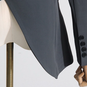 Detail of dark grey suit cuff with four black buttons and premium woven texture