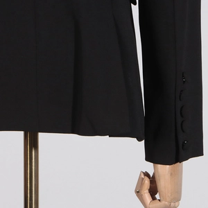 Detail of beaded blazer sleeve with four black decorative buttons and woven texture
