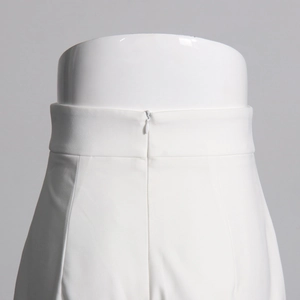 Détail du pantalon blanc taille haute avec fermeture éclair invisible et tissu en sergé