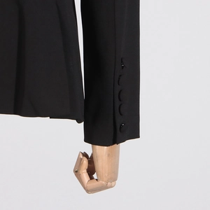 Close-up of black suit jacket sleeve with four matching buttons and twill texture fabric