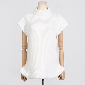 Detail of white chunky knit sleeveless sweater showing mock neck and rolled edge hem