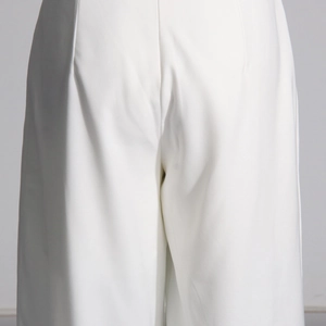 Gros plan sur un pantalon blanc à taille haute montrant le sergé et les plis