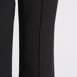 Detailed view of black trousers with vertical seam and textured fabric stitching