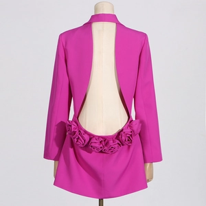 Détail d'une robe blazer dos nu fuchsia avec des roses en tissu 3D au bas du dos